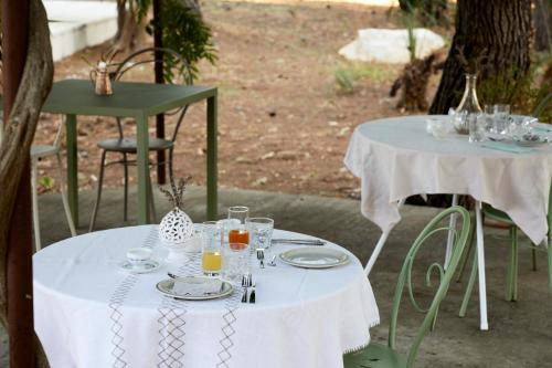 two tables with white table cloths and drinks on them at Petra - Country House in Monteroni di Lecce
