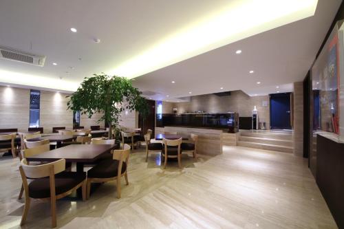 a restaurant with tables and chairs in a building at Golden Hotel Incheon in Incheon