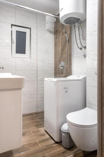 a white bathroom with a toilet and a sink at Heaven Premium apartments in Sarajevo