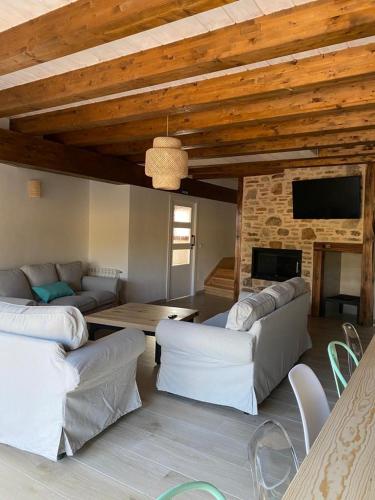 een woonkamer met witte banken en een open haard bij EL PAJAR DE LEONOR in Horcajuelo de la Sierra