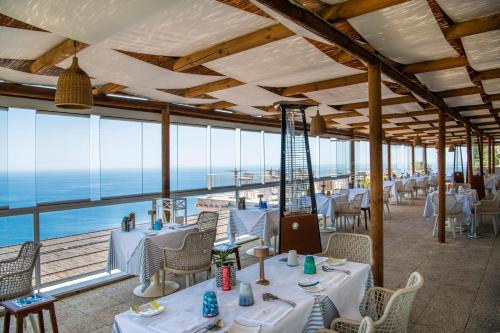 a restaurant with tables and chairs and a view of the ocean at Hotel Margherita in Praiano