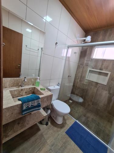 a bathroom with a sink and a toilet and a shower at Pássaros do Cerrado Suítes in Alto Paraíso de Goiás
