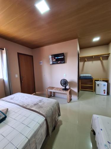 a bedroom with a bed and a tv on the wall at Pássaros do Cerrado Suítes in Alto Paraíso de Goiás