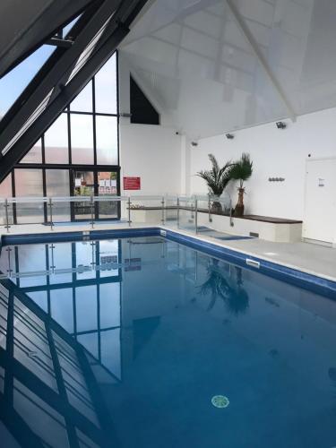 a swimming pool with blue water in a building at le Pullman in Deauville