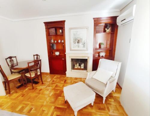 a living room with white chairs and a fireplace at Apartamento turístico San Juan in Pamplona