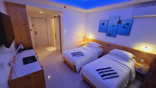 En eller flere senge i et værelse på Luau Beach Inn, Maldives