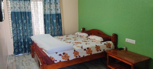 a small bedroom with a bed and a table at Akash homestay in Hampi