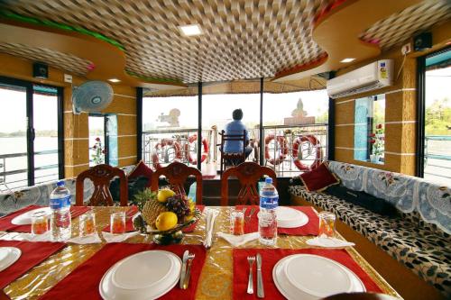 a dining room with a table in a train at Marari houseboat in Mararikulam