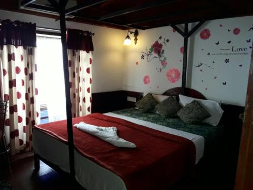 a bedroom with a bed with a red comforter at Sreekrishna Houseboat in Kumarakom