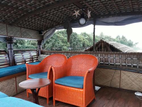 two chairs and a table on a train at Sreekrishna Houseboat in Kumarakom