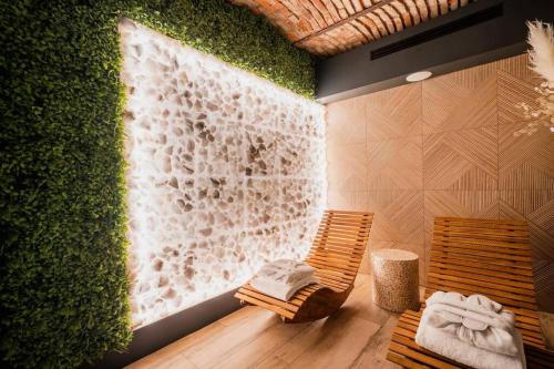 a room with a green wall and two wooden chairs at No 7 Apartament Spa z sauna i jacuzzi in Nowy Targ