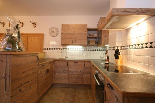 a kitchen with wooden cabinets and a counter top at Ferienappartement Royer in Schladming