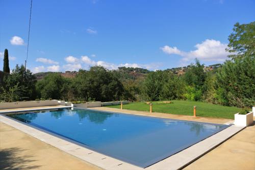 una gran piscina azul en un patio en La Quercia e l'Asino, en Piazza Armerina