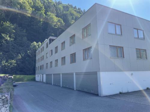 a large white building with a parking lot at Ferienwohnung Herold in Bartholomäberg