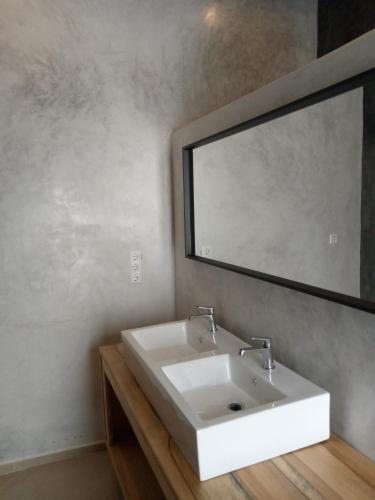 a bathroom with a white sink and a mirror at Kijani Beach Villas in Bwejuu