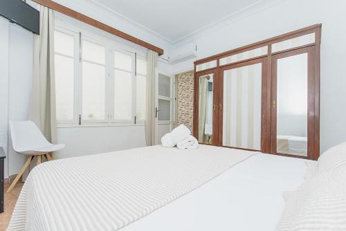 biała sypialnia z dużym łóżkiem i oknami w obiekcie Apartamento San Pascual en Orihuela w mieście Orihuela