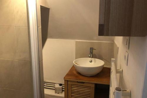 a bathroom with a white sink and a shower at Sous les toits in Dieppe