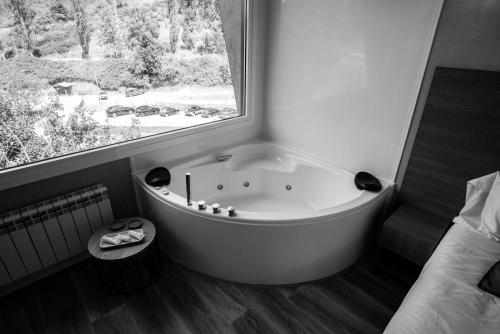 bañera en una habitación con ventana en CAMPING RESORT LA TRAPERA, en Pradoluengo