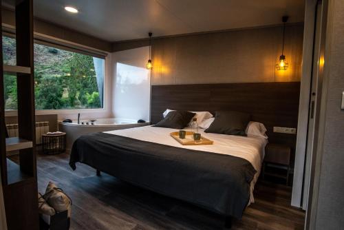 une chambre avec un lit et une baignoire dans l'établissement CAMPING RESORT LA TRAPERA, à Pradoluengo