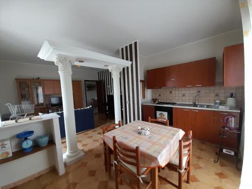 - une cuisine et une salle à manger avec une table et des chaises dans l'établissement Appartamento Marianna, à Piazza Armerina
