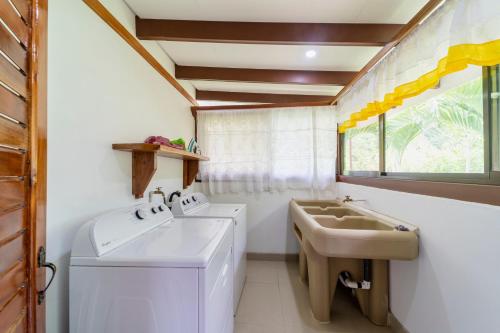 W łazience znajduje się umywalka, toaleta i lustro. w obiekcie Casa Blossom - Beach Paradise Retreat w mieście Puerto Viejo