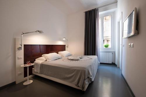 a bedroom with a bed with a table and a window at Inn Urbe Colosseo in Rome