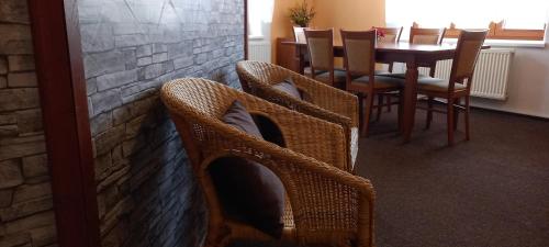 a dining room with wicker chairs and a table at Penzion U školy in Staré Město