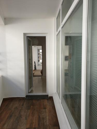 um corredor com uma porta de vidro e um espelho em Altavista Penthouse T2 na Covilh�