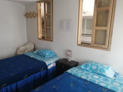 1 dormitorio con 2 camas y espejo en Escocie Quito Colonial, en Quito