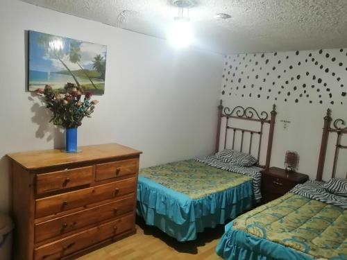 1 dormitorio con 2 camas y vestidor en Escocie Quito Colonial, en Quito