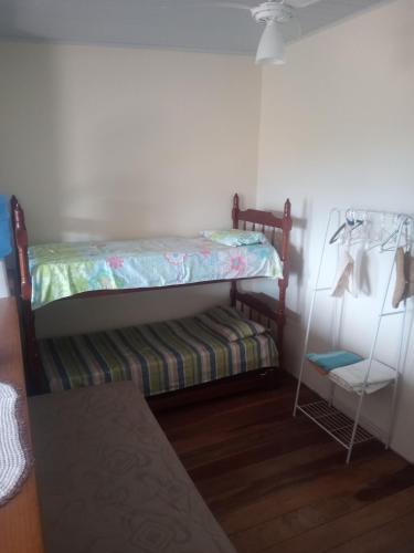 a small room with a bunk bed and a shelf at Nosso Pedacinho in Abraão