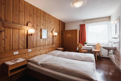 een slaapkamer met een bed, een bureau en een wastafel bij Apartments Roda de Ciar in Badia
