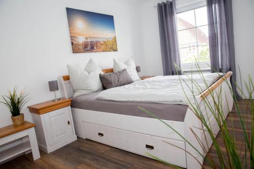 a bedroom with a white bed with a window at Appartement Nordlicht in Eutin