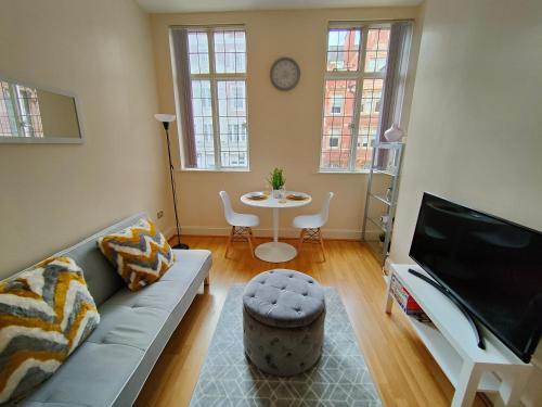 een woonkamer met een bank en een tafel bij Newhall Street Place in Birmingham