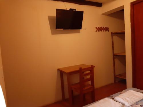 Habitación con mesa y TV en la pared. en Healthy Stay Gocta, en Cocachimba