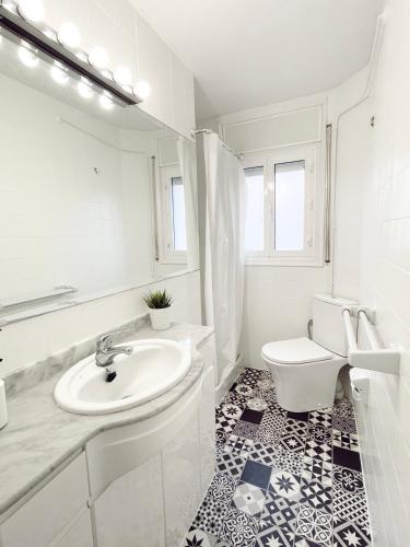 a white bathroom with a sink and a toilet at Sweet apartment in Calafell