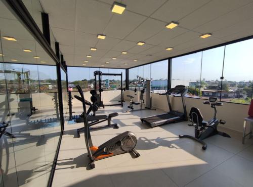 ein Fitnessstudio mit Laufbändern und Crosstrainern in einem Gebäude in der Unterkunft Hotel Nossa Casa in Ijuí