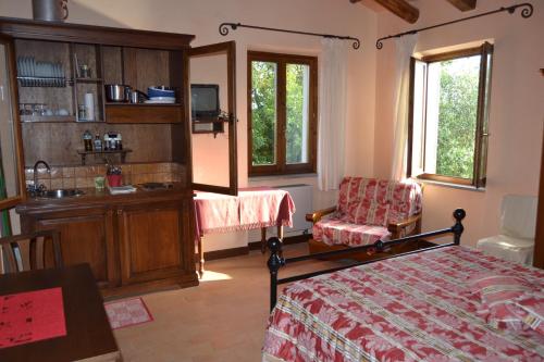 una camera con letto, scrivania e lavandino di Le Macchie a Baschi