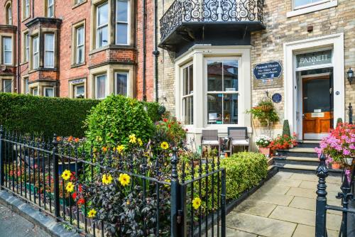 a house with a fence with flowers in front of it at Pannett House Bed & Breakfast, Beautiful Victorian residence in Whitby