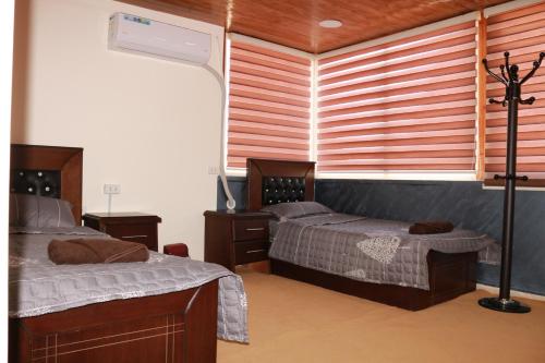 a bedroom with two beds and a window at Basant Villa in Wadi Musa