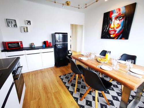 a dining room with a table and a refrigerator at Charmante Zentrumswohnung mit Balkon und 80 zoll TV in Klagenfurt