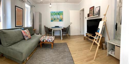 ein Wohnzimmer mit einem Sofa und einem Tisch in der Unterkunft Diva Garden Apartment in Plowdiw
