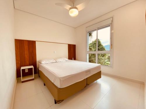 ein Schlafzimmer mit großem Bett und Fenster in der Unterkunft Vista Mágica em Camburizinho D in São Sebastião