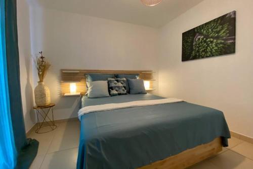 une chambre avec un grand lit avec des draps bleus dans l'établissement Escapade méditerranéenne, à La Seyne-sur-Mer