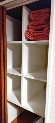 un placard avec des étagères blanches et une serviette rouge dans l'établissement Apartamento Libra 6, à Villa Gesell