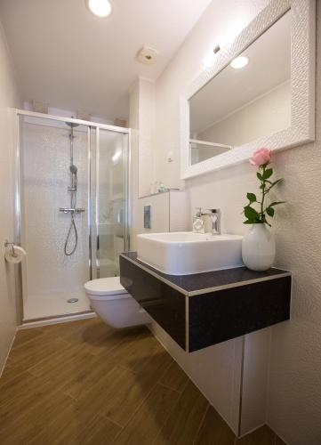 a bathroom with a sink and a toilet and a shower at Villa Flores Room in Dubrovnik