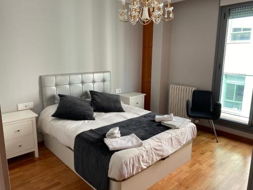 um quarto com uma cama com duas toalhas em Maison San Isidoro - GARAJE y WIFI GRATUITO em León