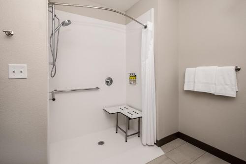 een witte badkamer met een douche en een wastafel bij Holiday Inn Express & Suites - Ft Myers Beach-Sanibel Gateway, an IHG Hotel in Fort Myers Beach