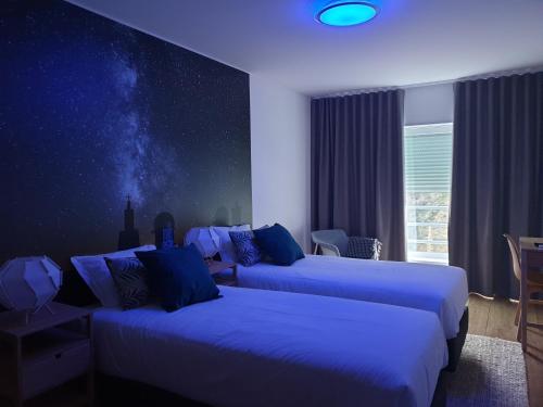 una habitación de hotel con 2 camas y una habitación estrellada en Altavista Penthouse T2, en Covilhã
