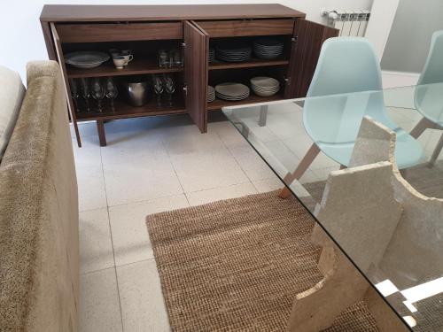 a glass table with a chair and a cabinet at Altavista Penthouse T2 in Covilhã